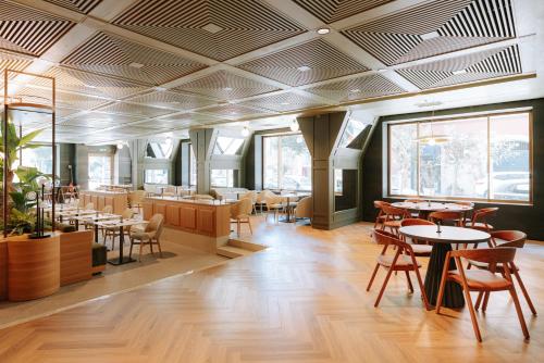a dining room with tables and chairs and windows at Mövenpick Hotel Bari in Bari