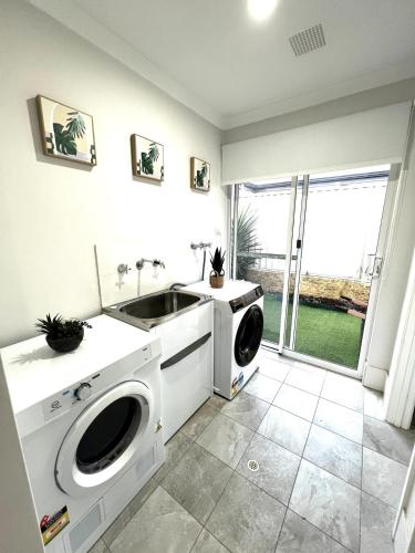 a laundry room with a washing machine and a sink at Baldivis Home Close to IGA, CAFE, Restaurants, 15 mins to beach in Baldivis