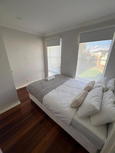 a large bed in a room with a large window at Baldivis Home Close to IGA, CAFE, Restaurants, 15 mins to beach in Baldivis