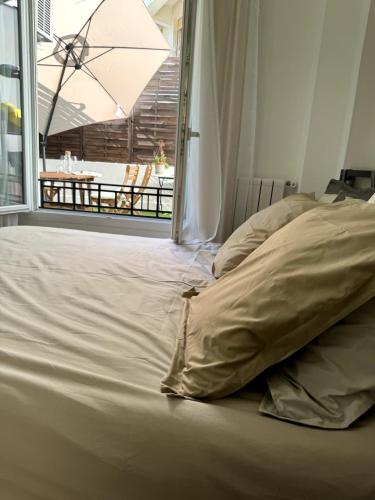 a bed in a room with a large window at Carré d'Or - 2P Cosy avec Terrasse et véranda in Nice