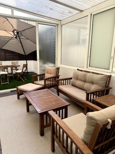 a screened in porch with benches and tables at Carré d'Or - 2P Cosy avec Terrasse et véranda in Nice