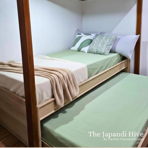 two bunk beds in a room with a green floor at Cozy Condo AC Wi-Fi Netflix Ligao Natl Rd Rm 303 in Ligao