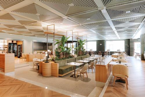 a restaurant with tables and chairs in a room at Mövenpick Hotel Bari in Bari
