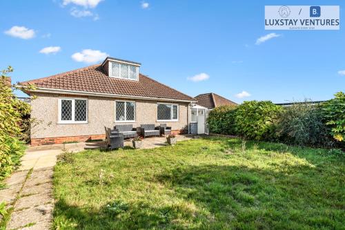 a house with a yard with a bench in the backyard at Spacious 3 Bedroom Brighton Home - South Downs - Stunning Sea Views - Garden - Pool Table - FREE Parking in Brighton & Hove