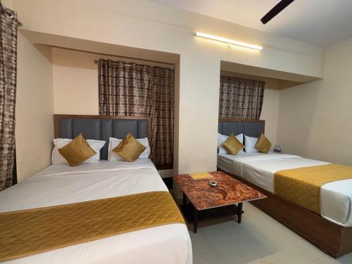 a hotel room with two beds and a table at Hotel Crystal Palace in Jāmb