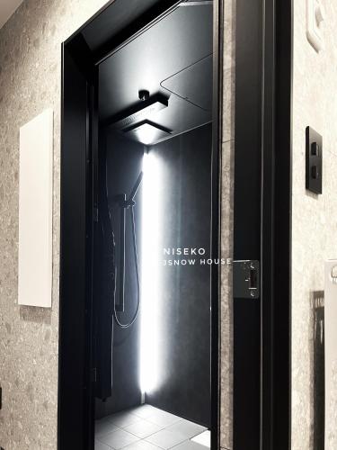 a bathroom with a black door with a shower in it at JY Snow in Kutchan