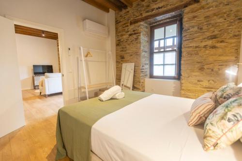 a bedroom with a large white bed in a room at Apartamentos Rurales Casa Carlota in Vegadeo