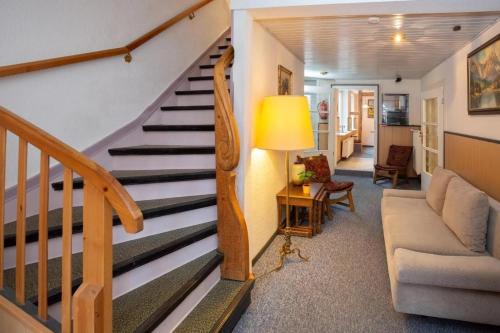 a living room with a staircase and a couch at Gruppenhaus Sankt Andreasberg Braunlage in Sankt Andreasberg