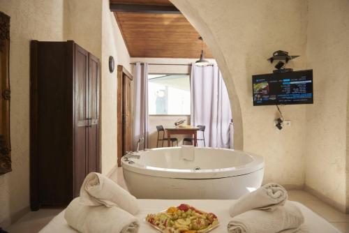 a bathroom with a tub and a plate of food at אחוזת כינורות in Tiberias