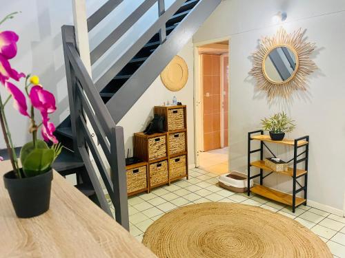 a living room with a staircase and a mirror at Maisons Familiales 101 m2 et 51 m2 Lagon, Plage & Détente, La Saline-les-Bains in La Saline les Bains