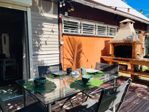 a table and chairs on a patio with a fireplace at Maisons Familiales 101 m2 et 51 m2 Lagon, Plage & Détente, La Saline-les-Bains in La Saline les Bains