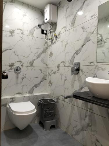 a bathroom with a white toilet and a sink at Hotel Paris Plaza in Ahmedabad