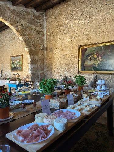 a table with meat and other food items on at Feudo Nobile in Gela