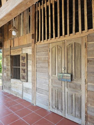 a barn with wooden doors and a tile floor at LA'S FARMSTAY in Trảng Bàng