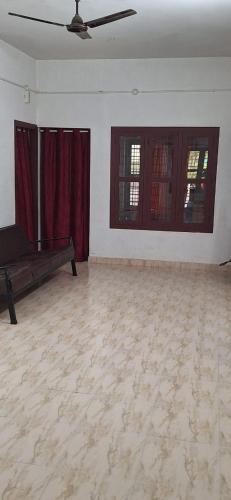 a living room with a couch and two windows at Holiday Apartments & Homestay in Sultan Bathery
