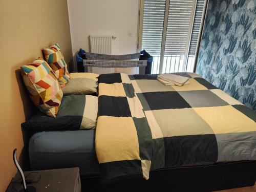 a bed with a quilt on it in a bedroom at Building carré d eden in Clamart