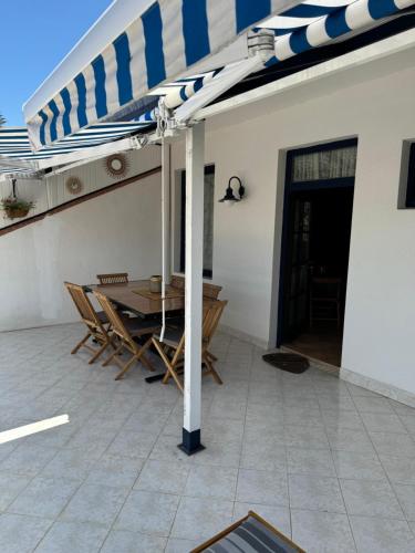 a table and chairs under an umbrella on a patio at Bel appartement à Oualidia in Oualidia