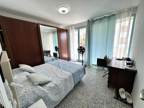 a bedroom with a bed and a desk and a window at Paseo de la Carretera in Benidorm