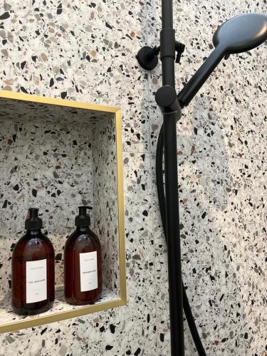 a mirror on a wall with two bottles of soap at Les Chambres du parc in Monnières