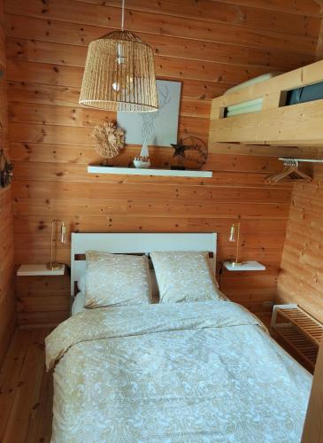 a bedroom with a bed in a wooden wall at Le Finland labélisé 3 étoiles in Bourbourg