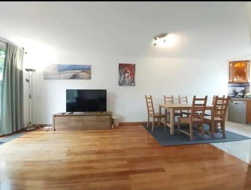 a living room with a table and a television at Villa with garden near Amsterdam in Almere