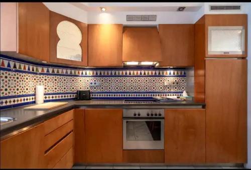 Una cocina con gabinetes de madera y un horno de estufa. en Villa with garden near Amsterdam, en Almere