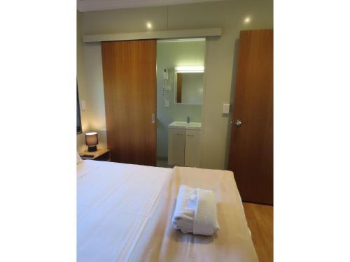 - une chambre avec un lit et une serviette dans l'établissement BIG4 Toowoomba Garden City Holiday Park, à Toowoomba
