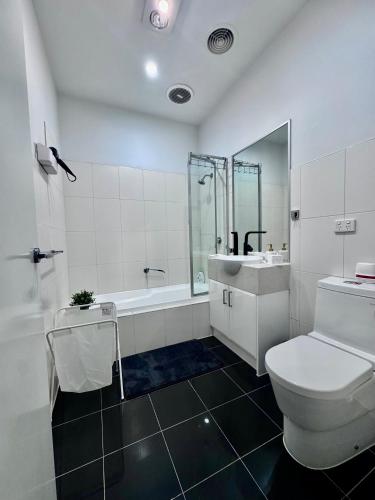 a bathroom with a toilet and a tub and a sink at Luxe Riverside Oasis 3BR for 6 Guests Home Near Flemington Racecourse 16 min to CBD 20 min to Airport 2 mins walk to Public Transport to go to Train Station and Highpoint Shopping Centre in Melbourne