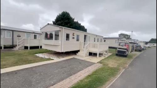 ein weißes winziges Haus in einem Hof in der Unterkunft Huttons butlins caravan hire in Ingoldmells