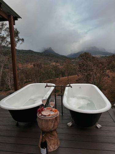 two bath tubs sitting on a deck with a view at Hilltop Haven Darlington in Darlington