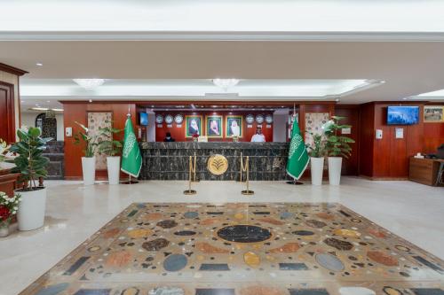 a lobby with a table with flags on it at Al Shohada by Palm Rich Makkah in Makkah