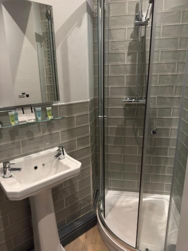 a bathroom with a sink and a shower at Red Lion Inn Wybunbury in Wybunbury