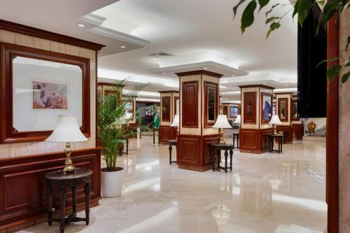 a lobby with wood paneling and tables and lamps at Al Shohada by Palm Rich Makkah in Makkah