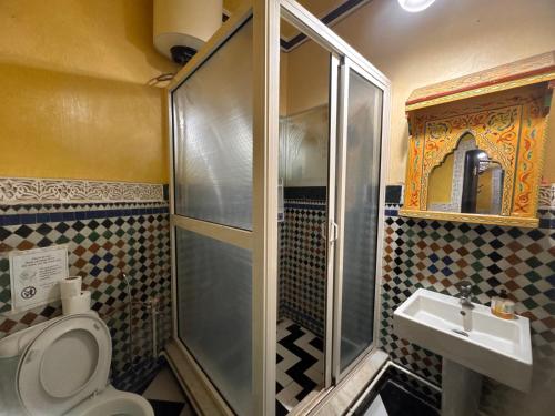 a bathroom with a shower and a toilet and a sink at Riad Mogador in Meknès