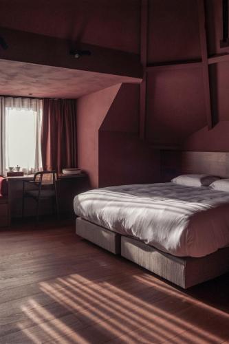 a bedroom with a large bed and a window at Hostellerie Kemmelberg in Kemmel