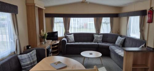 a living room with a couch and a table at Superb 8 Berth Dog Friendly Caravan To Hire In Norfolk Ref 10054B in Belton