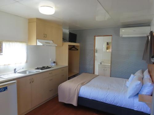 a bedroom with a bed and a kitchen with a sink at BIG4 Toowoomba Garden City Holiday Park in Toowoomba