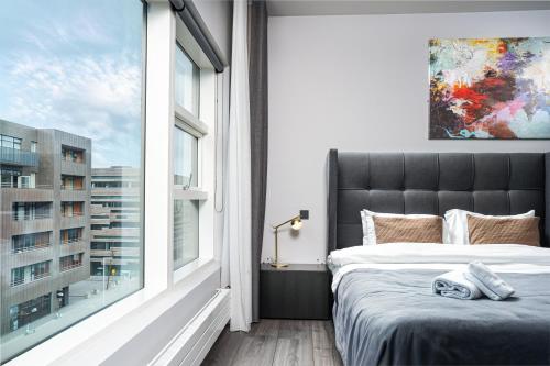 a bedroom with a bed and a large window at Unbeatable Central Location - Reykjavíks Most Exclusive Luxury Apartments in Reykjavík