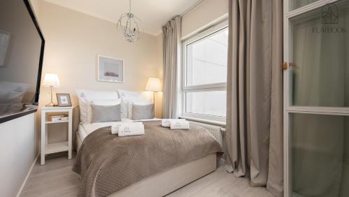 a bedroom with a bed with two towels on it at Flatbook Seaside Baltica Tower - Apartment with Sea View, Gym & Parking in Gdańsk