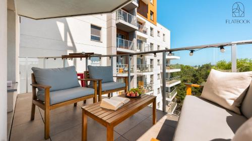 a balcony with chairs and a table on a building at Flatbook Seaside Baltica Tower - Apartment with Sea View, Gym & Parking in Gdańsk