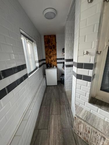 a bathroom with white and black tiles on the wall at OYO Shore Surf Lodge in Newquay
