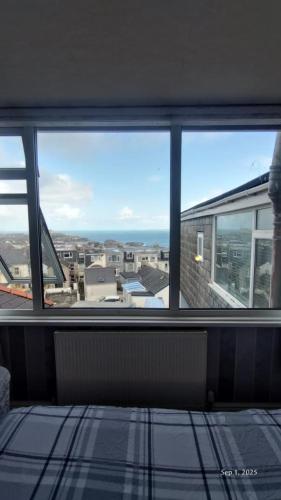 a room with a window with a view of the ocean at OYO Shore Surf Lodge in Newquay