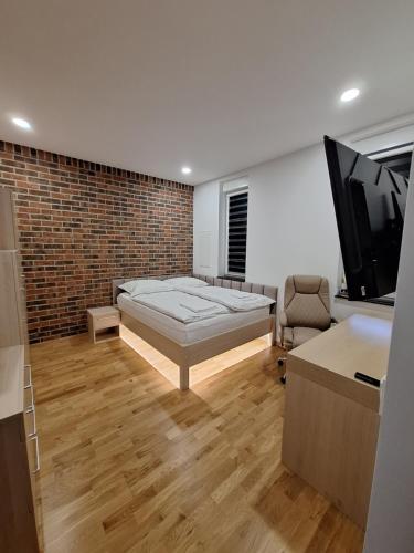 a bedroom with a bed and a flat screen tv at Hotel Alhar in Lubliniec