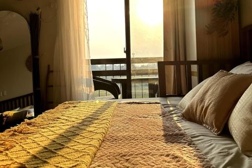 une chambre avec un lit et une grande fenêtre dans l'établissement Balinest Studio Tagaytay, à Tagaytay