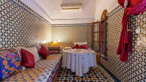 a living room with a couch and a table at Riad Dar Pierre in Fès
