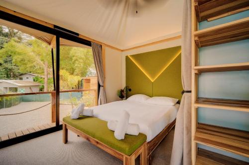 a bedroom with a bed and a large window at Evia Life Resort in Puerto Viejo