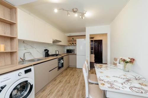 a kitchen with a table and a washing machine at LuxRent in Chişinău