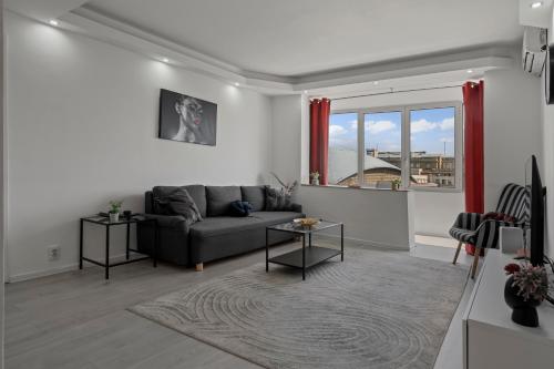 a living room with a couch and a window at Quiet Apartment Ruby Horizon in Bucharest