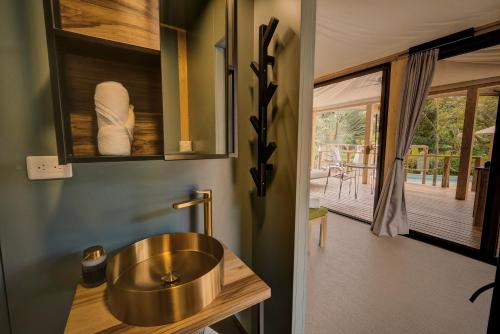 a bathroom with a copper sink and a balcony at Evia Life Resort in Puerto Viejo