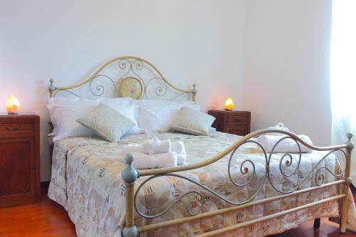 Una cama en un dormitorio con dos mesitas de noche y dos velas. en Relax Merigge - Piscina a Comune - Parcheggio, en Pieve a Maiano